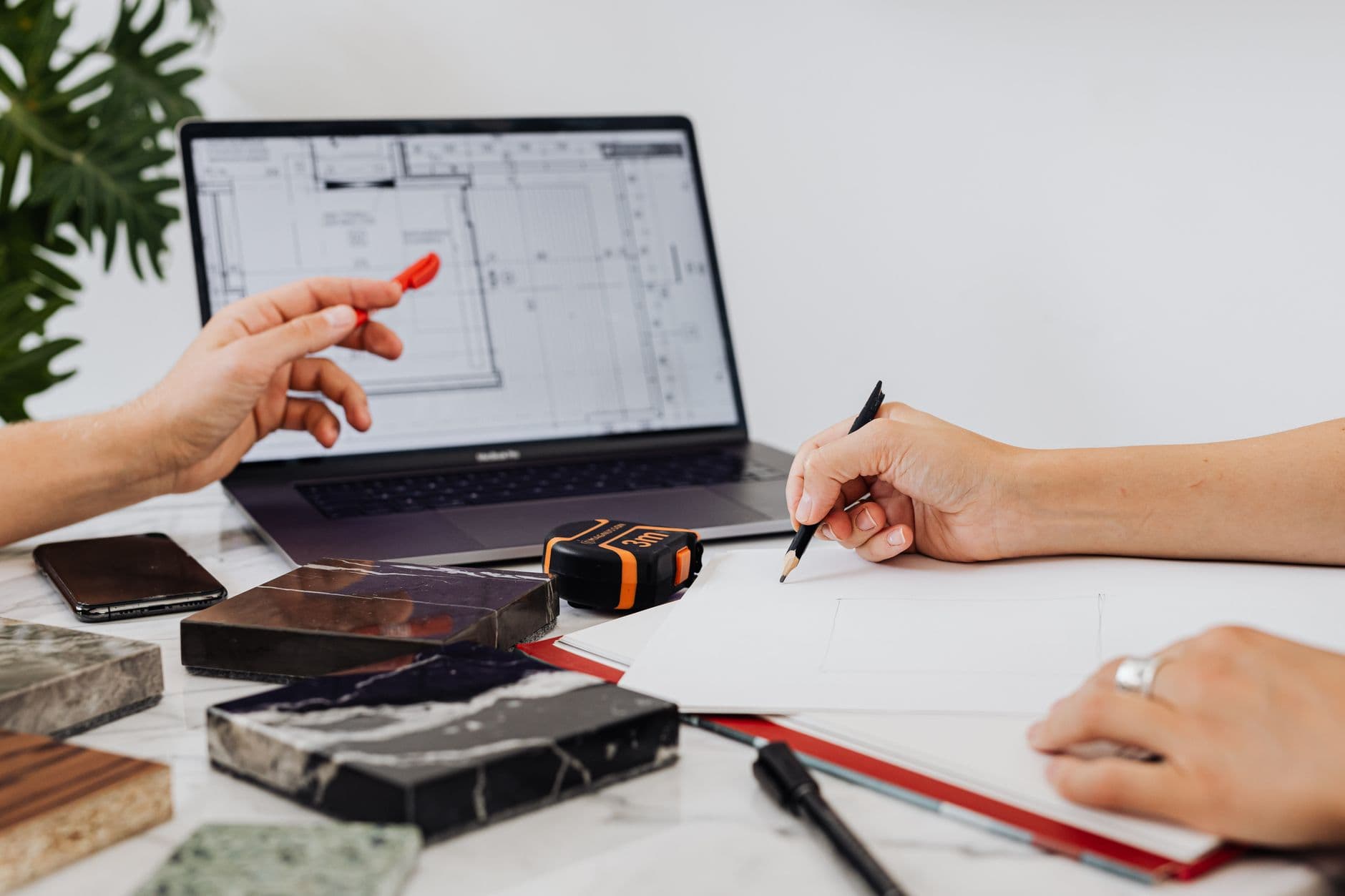 Tile samples and a pencil laid beside a plan set, the moment a selections checklist is meant to capture