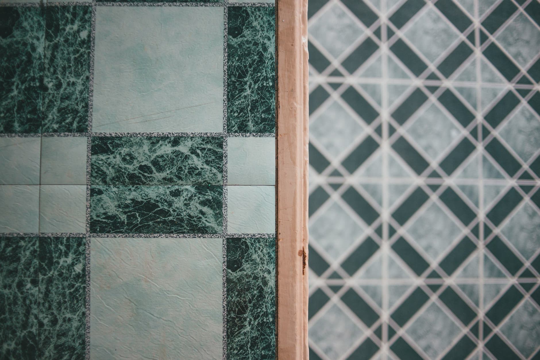 Two ceramic tile patterns meeting at a threshold, the exact finish a spec sheet has to name so the wrong one does not show up